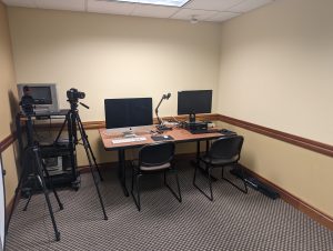 Image of the digital production studio showing two computers, a table and various recording equipment.